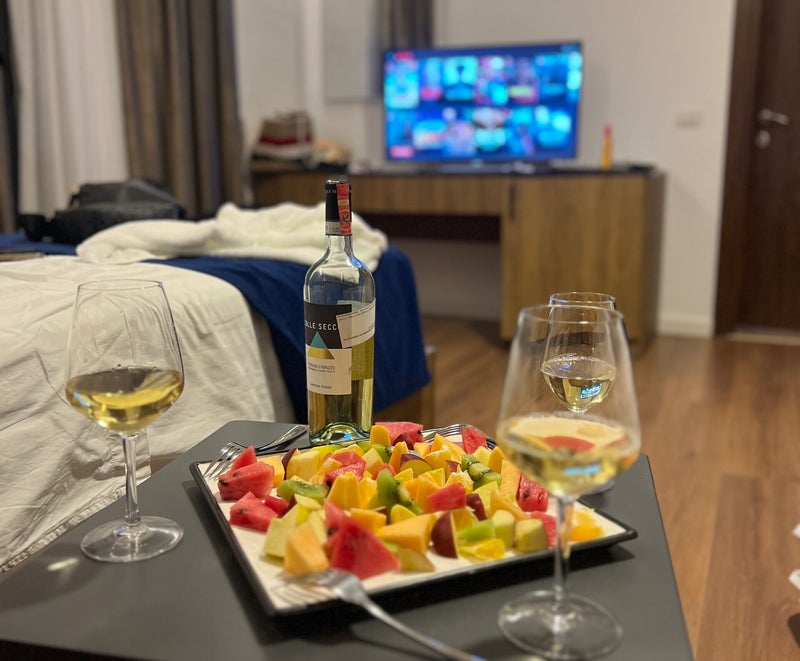 Fruit platter and wine glasses prepared at a table in a Krial guest room.